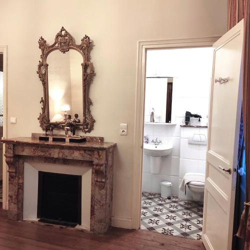 La salle de bains est pourvue d'une cheminée et d'un miroir. dans l'établissement Villa Angel - SPA, à Caunes-Minervois