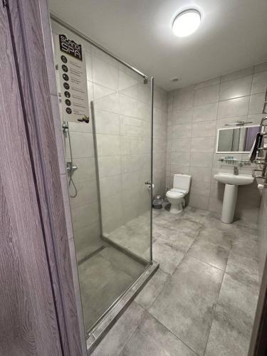 a bathroom with a shower with a toilet and a sink at Готель-спа "Еліт" in Kolʼchyno