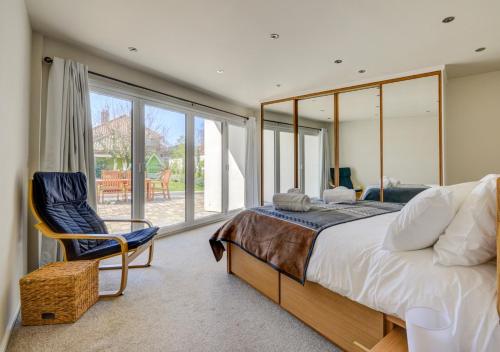 a bedroom with a large bed and a chair at The Eye in Sheringham