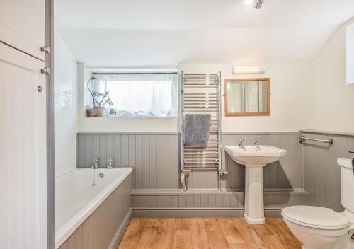a bathroom with a tub sink and a toilet at Flint Cottage - Bodham in Bodham