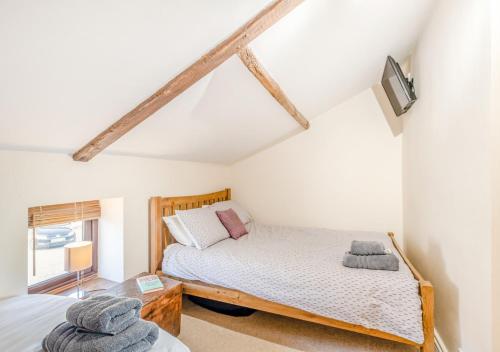 a bedroom with two beds and a window at Flint Cottage - Bodham in Bodham