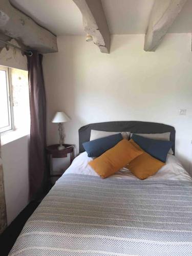 - une chambre avec un lit doté d'oreillers bleus et oranges dans l'établissement Aux portes de Périgueux, à Notre-Dame-de-Sanilhac