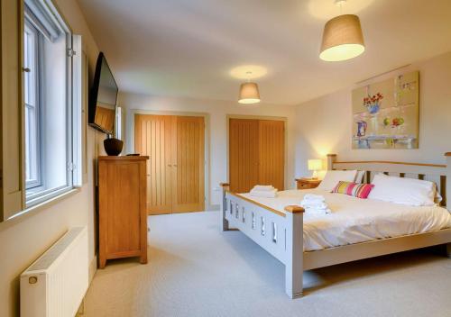 a bedroom with a white bed and a window at Yew Tree House in Weybourne