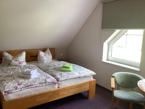 1 dormitorio con 1 cama con ventana y silla en Pension Scherzer, en Ohorn