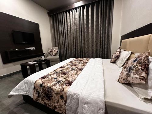 ein Schlafzimmer mit einem großen Bett und einem TV in der Unterkunft HOTEL KANAL KOTA in Kota
