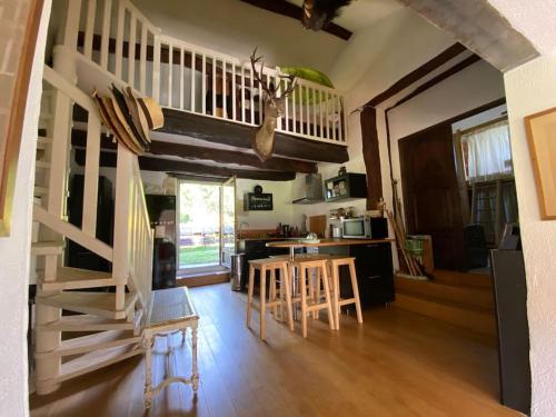 - un salon avec un escalier, une table et des chaises dans l'établissement Aux portes de Périgueux, à Notre-Dame-de-Sanilhac