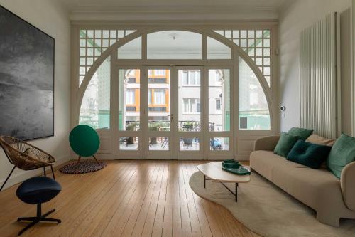 a living room with a couch and a large window at Spacious Belle Epoque House with free parking in Ostend