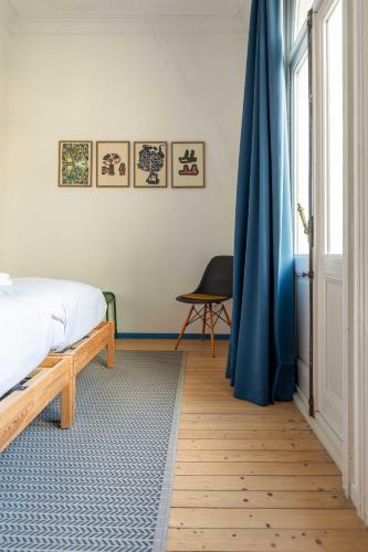 a bedroom with a bed and a blue curtain at Spacious Belle Epoque House with free parking in Ostend