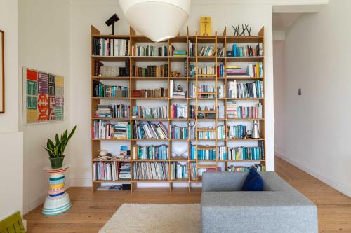 a book shelf filled with books in a living room at Spacious Belle Epoque House with free parking in Ostend