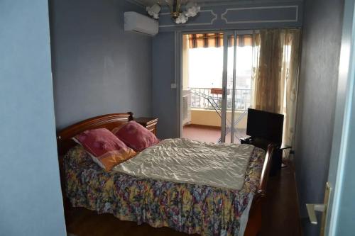 une chambre avec un lit avec des oreillers et une fenêtre dans l'établissement Appartement confortable à Ajaccio avec balcon, à Ajaccio
