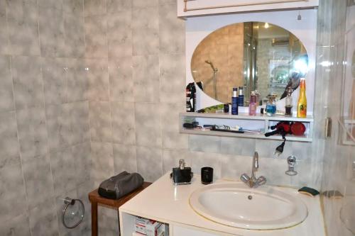 une salle de bain avec un lavabo et un miroir dans l'établissement Appartement confortable à Ajaccio avec balcon, à Ajaccio