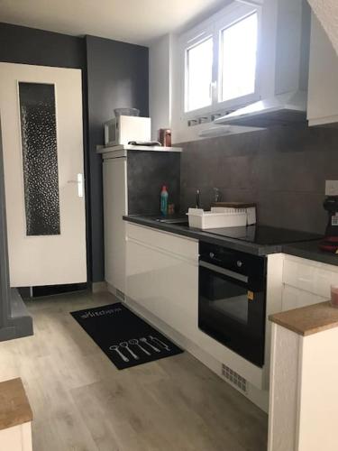 - une cuisine équipée d'un four avec plaques de cuisson en noir et blanc dans l'établissement La vigne et la Loire, à Pouilly-sur-Loire