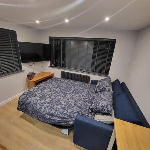 a bedroom with a bed and a blue couch at Town Centre Modern 1 Bed self-contained Apartment in Newbury