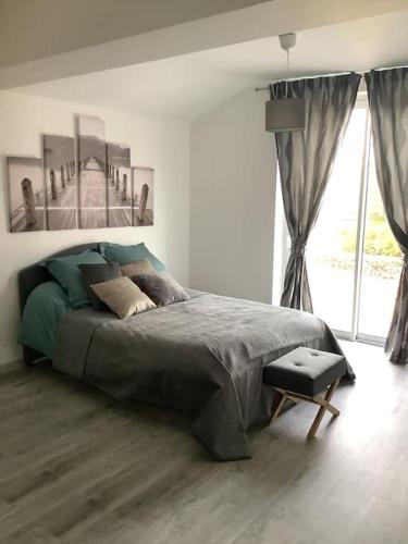 une chambre avec un grand lit et une grande fenêtre dans l'établissement La vigne et la Loire, à Pouilly-sur-Loire