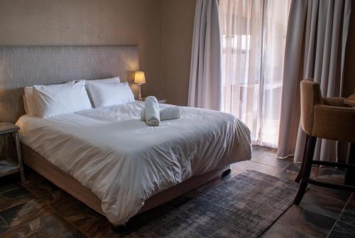 Una cama con un animal de peluche en un dormitorio en Casa de la Presa 2 en Polokwane