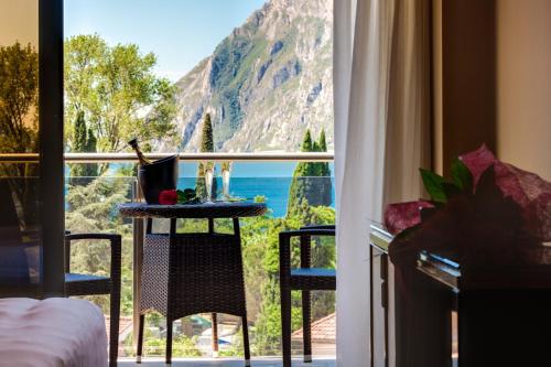 a room with a view of the ocean from a window at Garda Suite Hotel - TonelliHotels in Riva del Garda