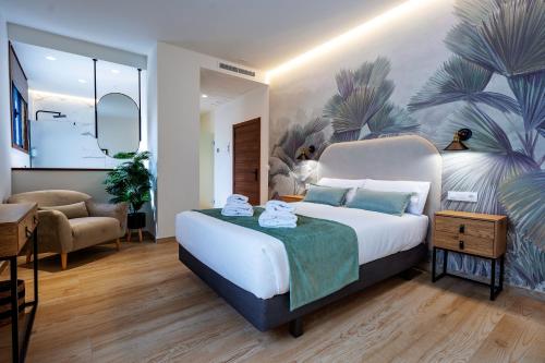 Complejo Valle Grande في Zarza la Mayor: غرفة نوم بسرير كبير عليها لوحة كبيرة على الحائط