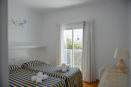 a bedroom with two beds and a sliding glass door at Apartamento Ciel Azul in Cala Llenya