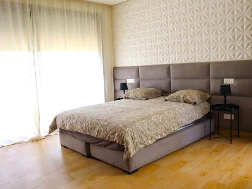 um quarto com uma cama grande e uma janela grande em Villa Noura Marrakech em Marrakech