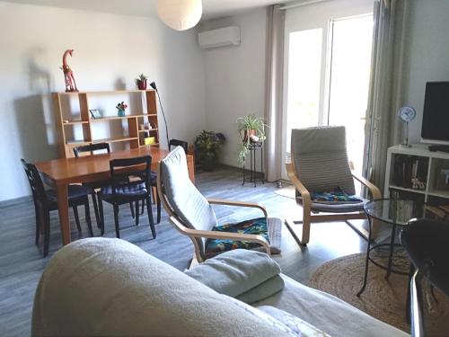 uma sala de estar com um sofá, uma mesa e cadeiras em la maison du verseau em Saint-Maime