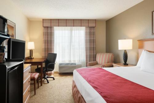 a hotel room with a bed and a desk at Country Inn & Suites by Radisson, Davenport, IA in Davenport