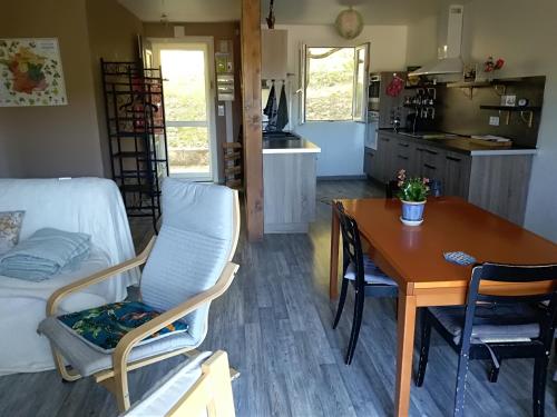 uma cozinha e sala de estar com mesa e cadeiras em la maison du verseau em Saint-Maime