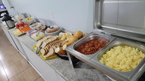 a buffet of food on a counter in a refrigerator at Hotel Calema in Capitão Leônidas Marques