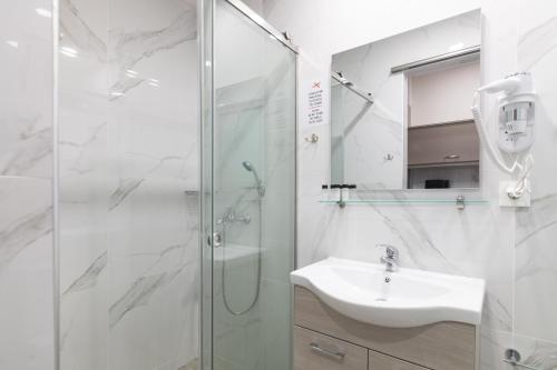 uma casa de banho com um chuveiro e um lavatório. em Sea Diamond Suites em Laganas