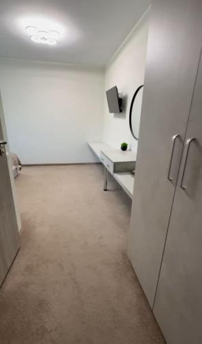 an empty white room with a table and a refrigerator at Готель-спа "Еліт" in Kolʼchyno