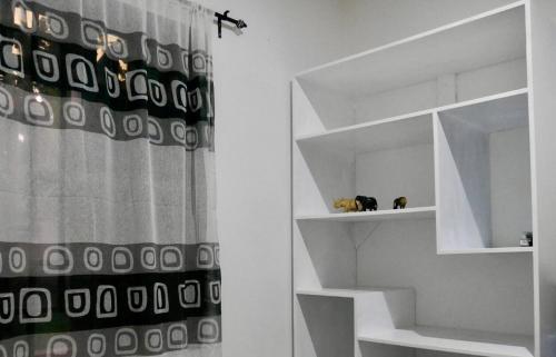 La salle de bains est pourvue d'un rideau de douche noir et blanc. dans l'établissement Green Living Apartment, à Nkoanrua