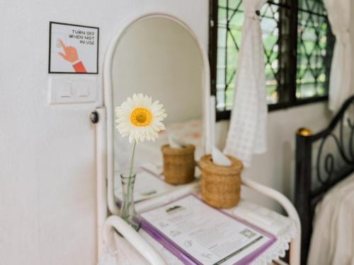 a table with a mirror and a flower on it at Ao Luek Homie Homestay in Krabi town