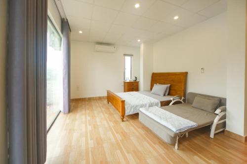 ein Zimmer mit 2 Betten und einem Sofa darin in der Unterkunft Trang Trại Gia Trịnh in Hanoi
