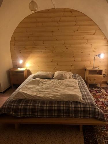 a bed in a room with a wooden wall at Cottage au trabuech in Lus-la-Croix-Haute