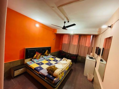 a bedroom with a bed with an orange wall at hotel new sahil in Srinagar