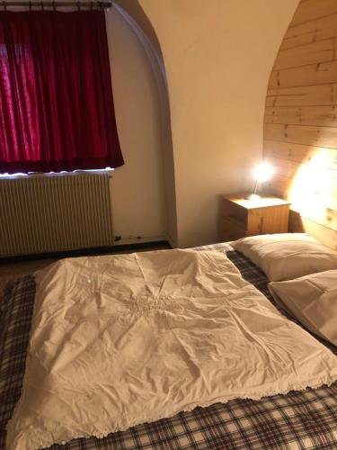 a large bed in a bedroom with a red window at Cottage au trabuech in Lus-la-Croix-Haute