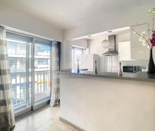 une cuisine avec un comptoir et une grande fenêtre dans l'établissement Grand 2 pieces- Marche Forville, à Cannes