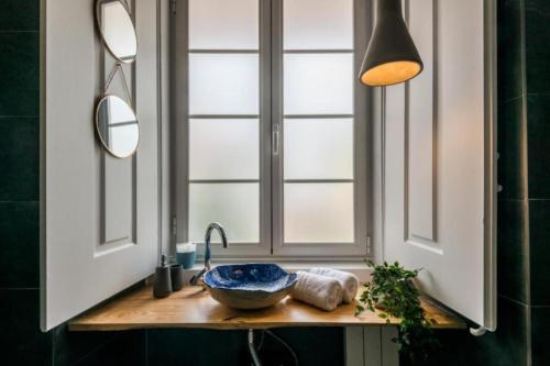 a bathroom sink with a bowl and a window at 19 Tile Ceramic Concept - by Unlock Hotels in Caldas da Rainha