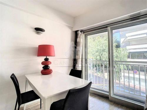 une pièce avec une table, des chaises et une fenêtre dans l'établissement Grand 2 pieces- Marche Forville, à Cannes