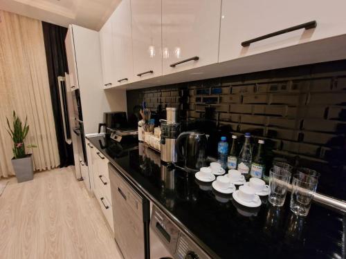 a kitchen with a black counter top with dishes on it at Houses for COP29 in Baku