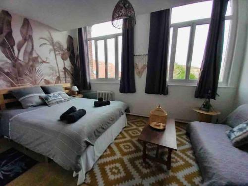 een slaapkamer met een bed, een bank en ramen bij Domaine Les Tourelles 3 in Caffiers