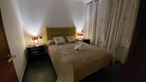 een slaapkamer met een groot bed met 2 lampen erop bij Alojamientos Marel Sanabria in Villarino de Sanabria