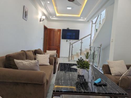 a living room with two couches and a table at West Coast Villa in Limbe