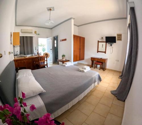 Irene Hotel Leros في أليندا: غرفة نوم بسرير كبير ومكتب