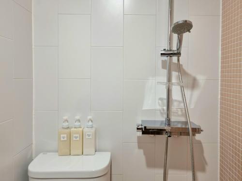 a white bathroom with a shower and a toilet at Hotel Lana in Gangneung