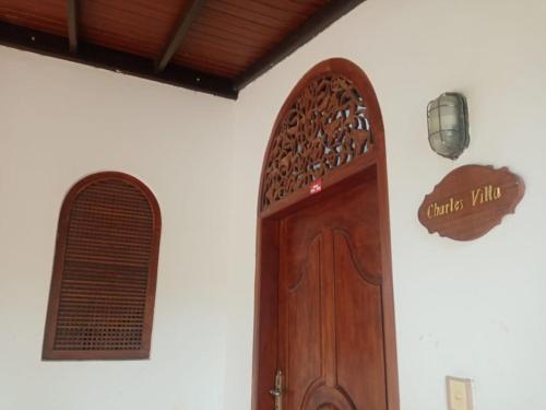 um quarto com uma porta de madeira e uma janela em Challsvilla Holiday Family Rooms Matara em Kekanadura