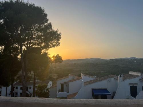 a sunset over a village with white houses and trees at Casa Nova, Moraira in Moraira