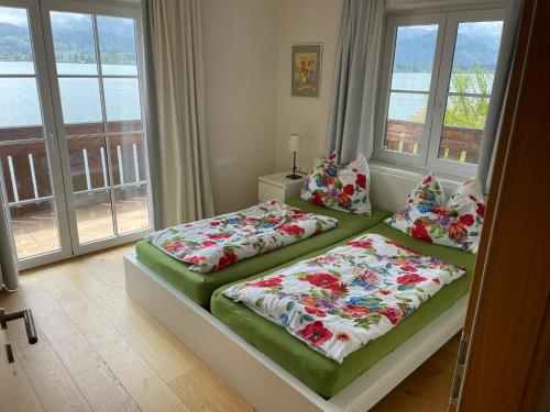twee bedden in een kamer met ramen bij Wallner am See in St. Wolfgang