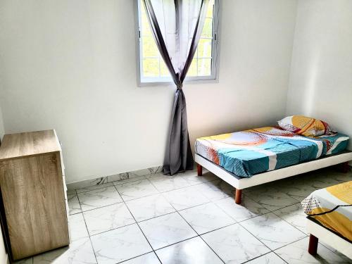 a small bedroom with a bed and a window at VUE MAGNIFIQUE SUR LA NATURE , proche des plages 4 a 6 PERS in Rivière-Pilote