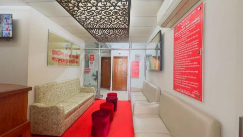 a waiting room with a couch and a red carpet at Hotel Rose Garden Palace Residential in Dhaka