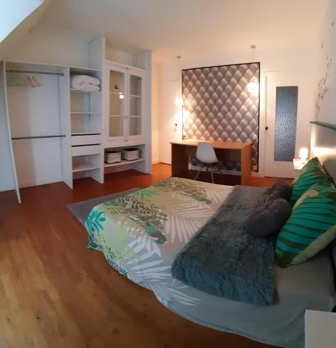 1 dormitorio con 1 cama grande y escritorio en Chambre-Suite (SDB & Cuisinette) centre historique Bourges, en Bourges